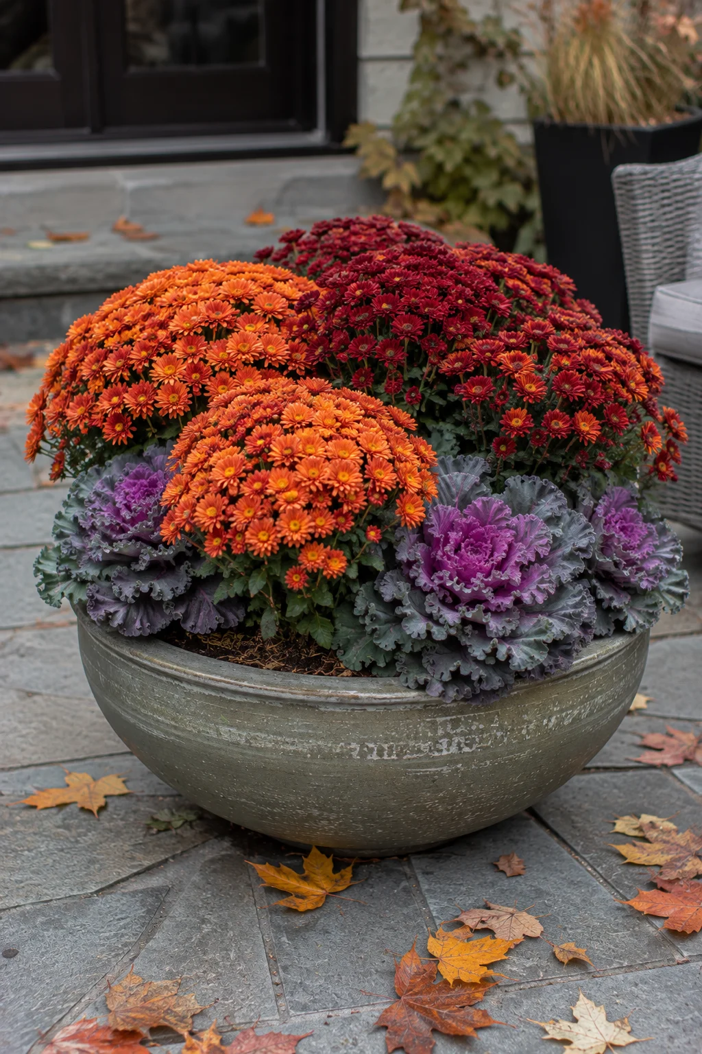 Fall planter with mums and ornamental kale on a patio